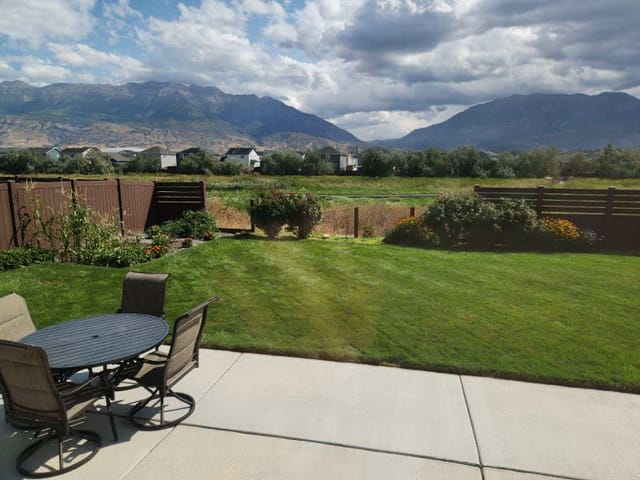 Backyard patio and wooden fence with Utah mountains in the background